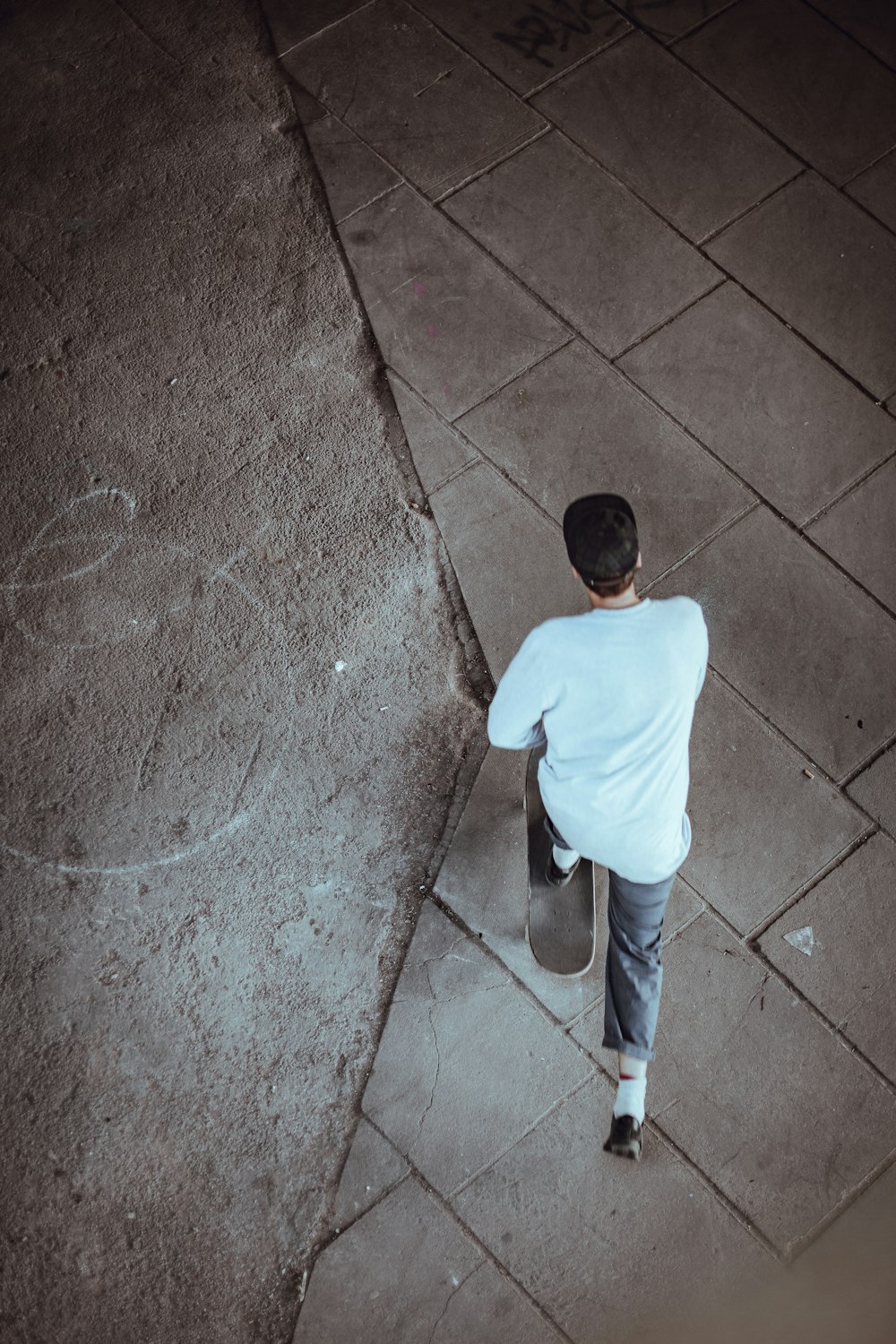 Mann mit weißem Hemd und schwarzer Mütze beim Skateboardfahren