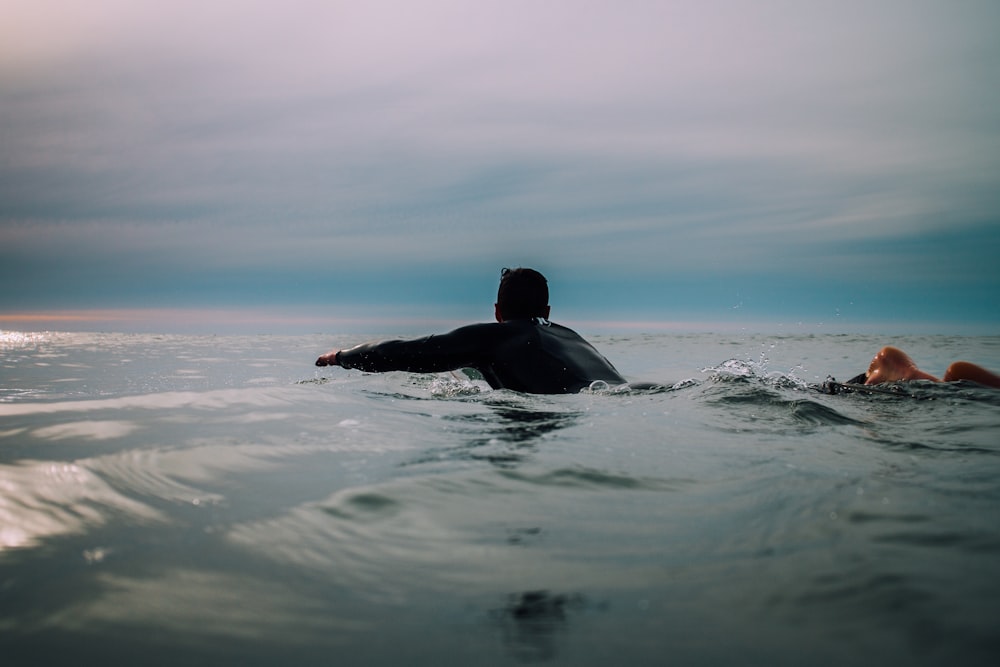 hombre con camisa negra en el cuerpo de agua