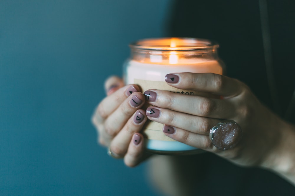 person holding white candle with light