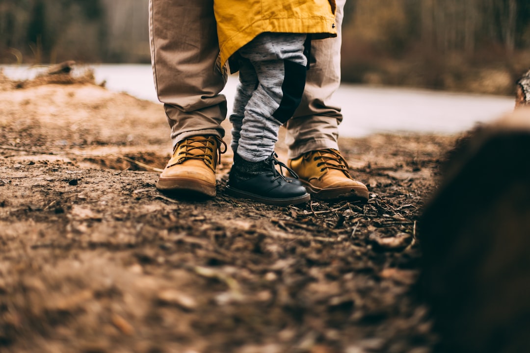 two person step on gray soil, boots