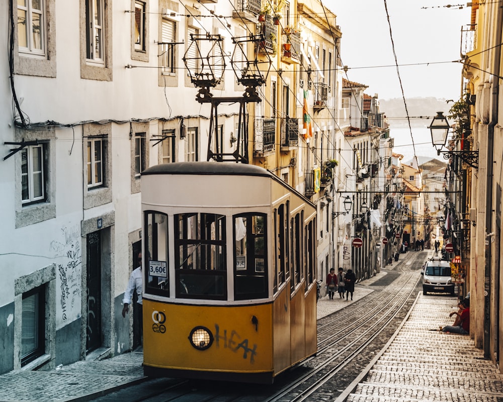 white and brown tram in between buildings at daytime