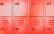 A happy customer standing next to a row of sturdy lockers in a bright, organized space.
