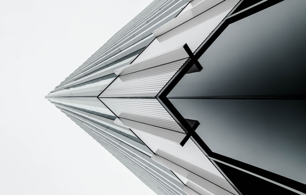 low-angle photography of black and gray building under white sky at daytime