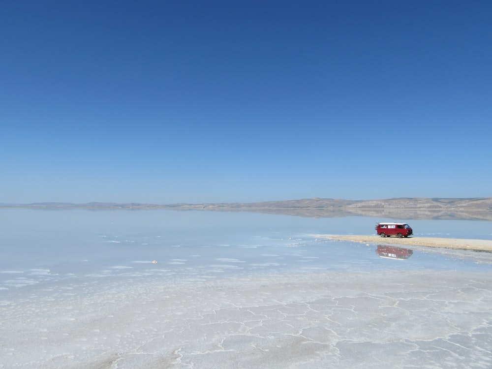 red and white van near sea under blue sky