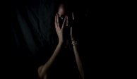 woman holding her face in dark room