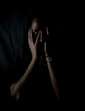 woman holding her face in dark room