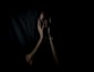 woman holding her face in dark room