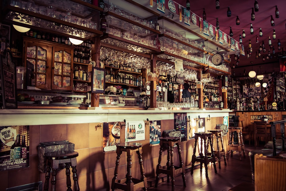 Das Interieur einer Bar mit Hockern, Glasbechern und leeren Flaschen, die auf dem Dach in Madrid befestigt sind