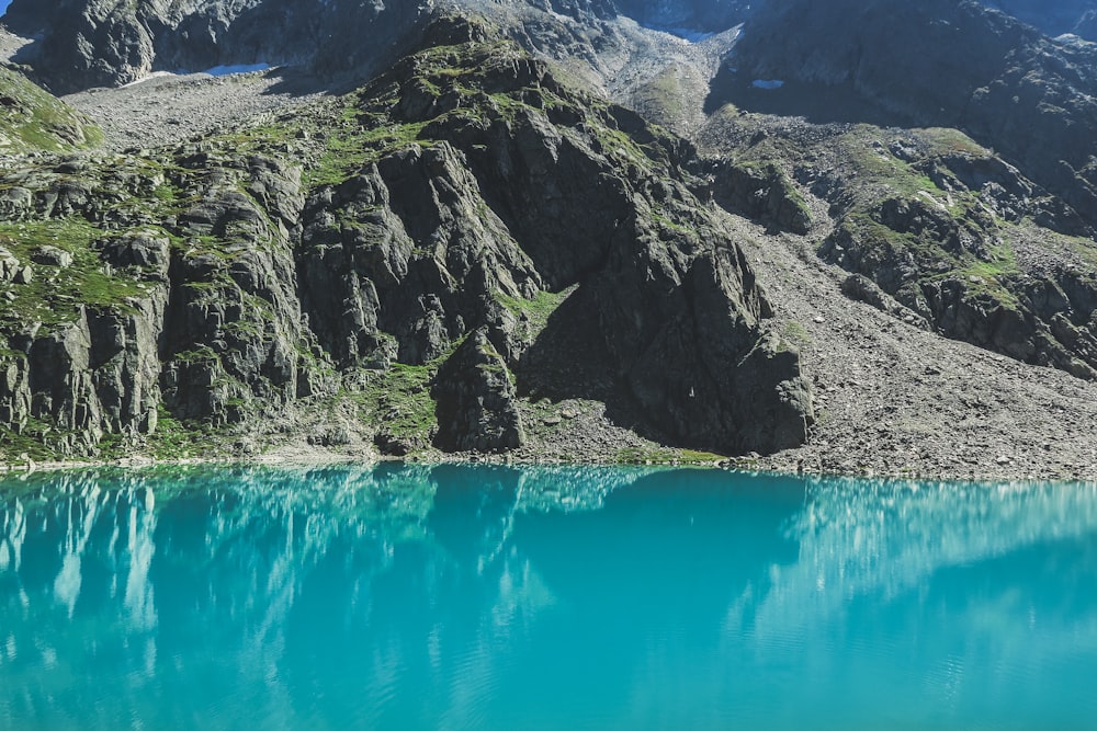 blue lake in the middle of green and gray mountains