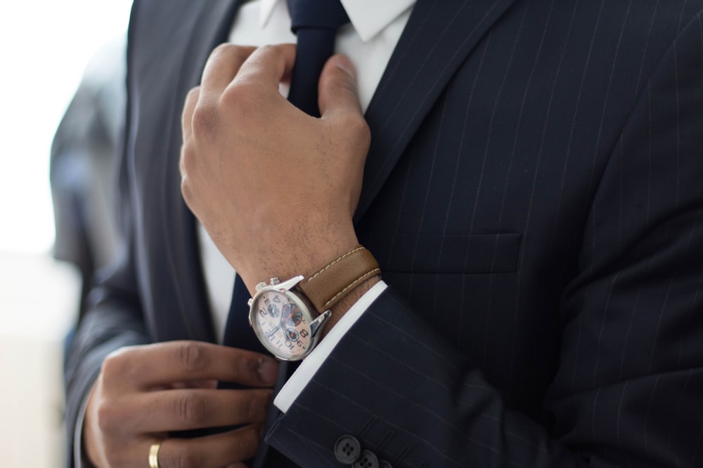 homme portant une montre avec un costume noir