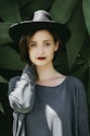 woman standing near trees wearing black hat