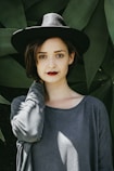 woman standing near trees wearing black hat