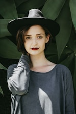 woman standing near trees wearing black hat