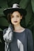 woman standing near trees wearing black hat