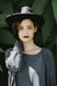 woman standing near trees wearing black hat