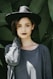 woman standing near trees wearing black hat