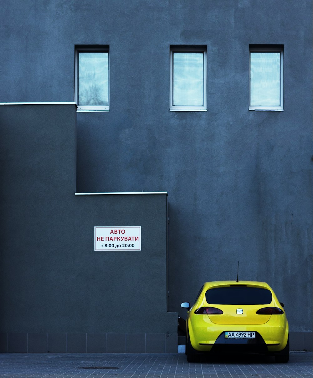Aparcamiento amarillo SEAT cerca de un edificio de hormigón