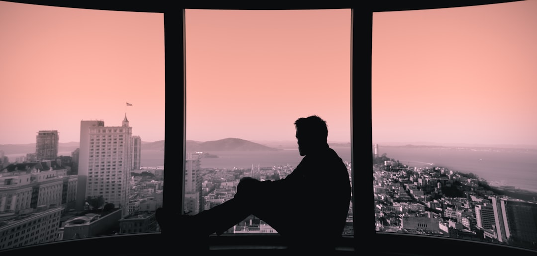 silhouette of person sitting on building