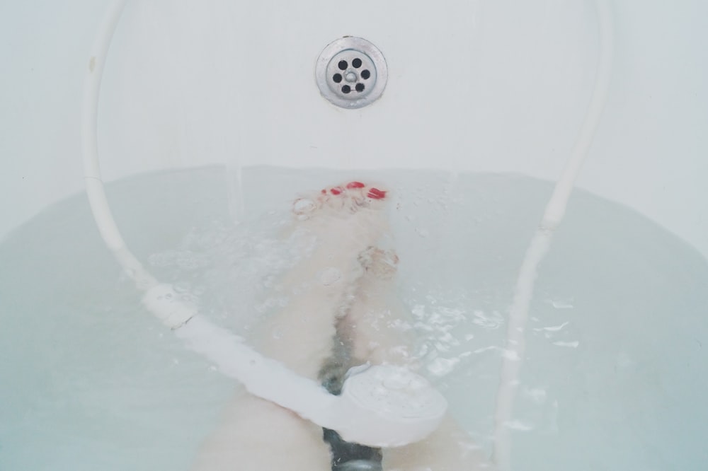 person sitting in white bathtub