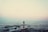 silhouette of person standing on sea dock under cloudy sky
