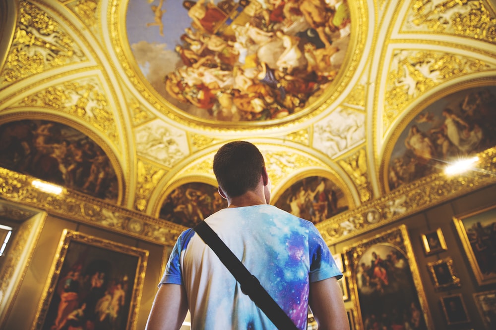 man wearing multicolored shirt standing inside room