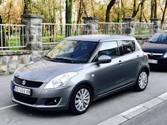 A Swift Dzire parked near a bustling market street, ready for a quick city trip.
