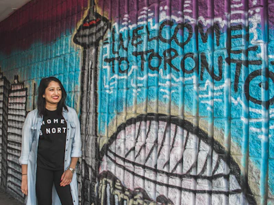 A friendly outreach representative engaging warmly with a passerby in a busy Toronto street.