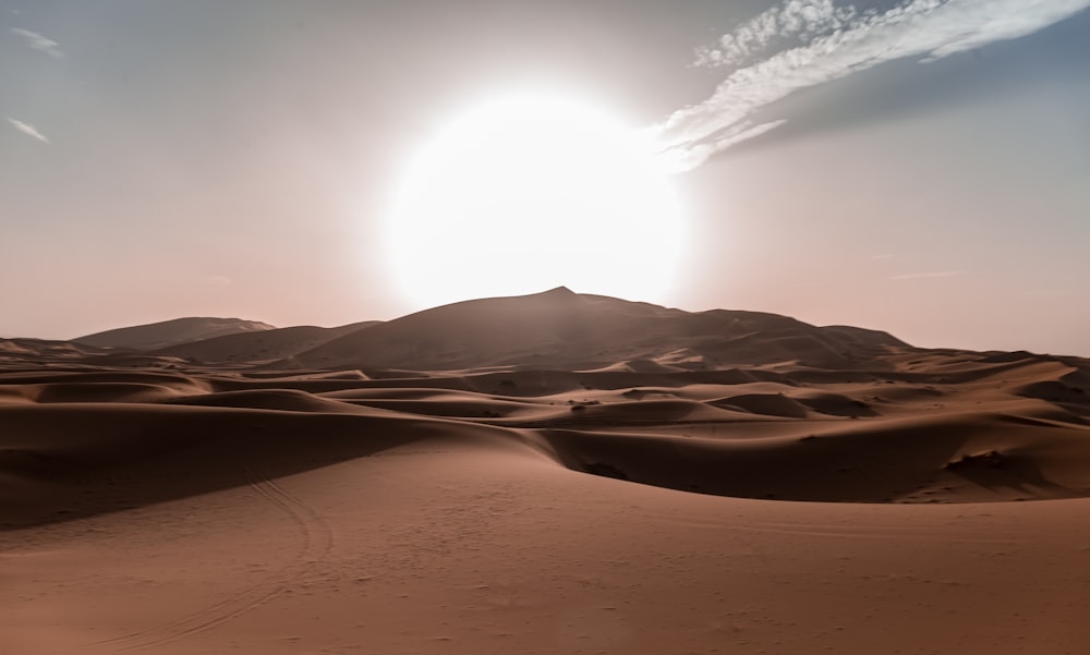 Sun rides over rolling sand dunes of the Sahara Desert