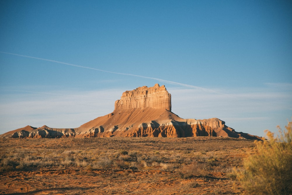 Formation rocheuse brune au sommet d’une colline sous un ciel bleu pendant la journée