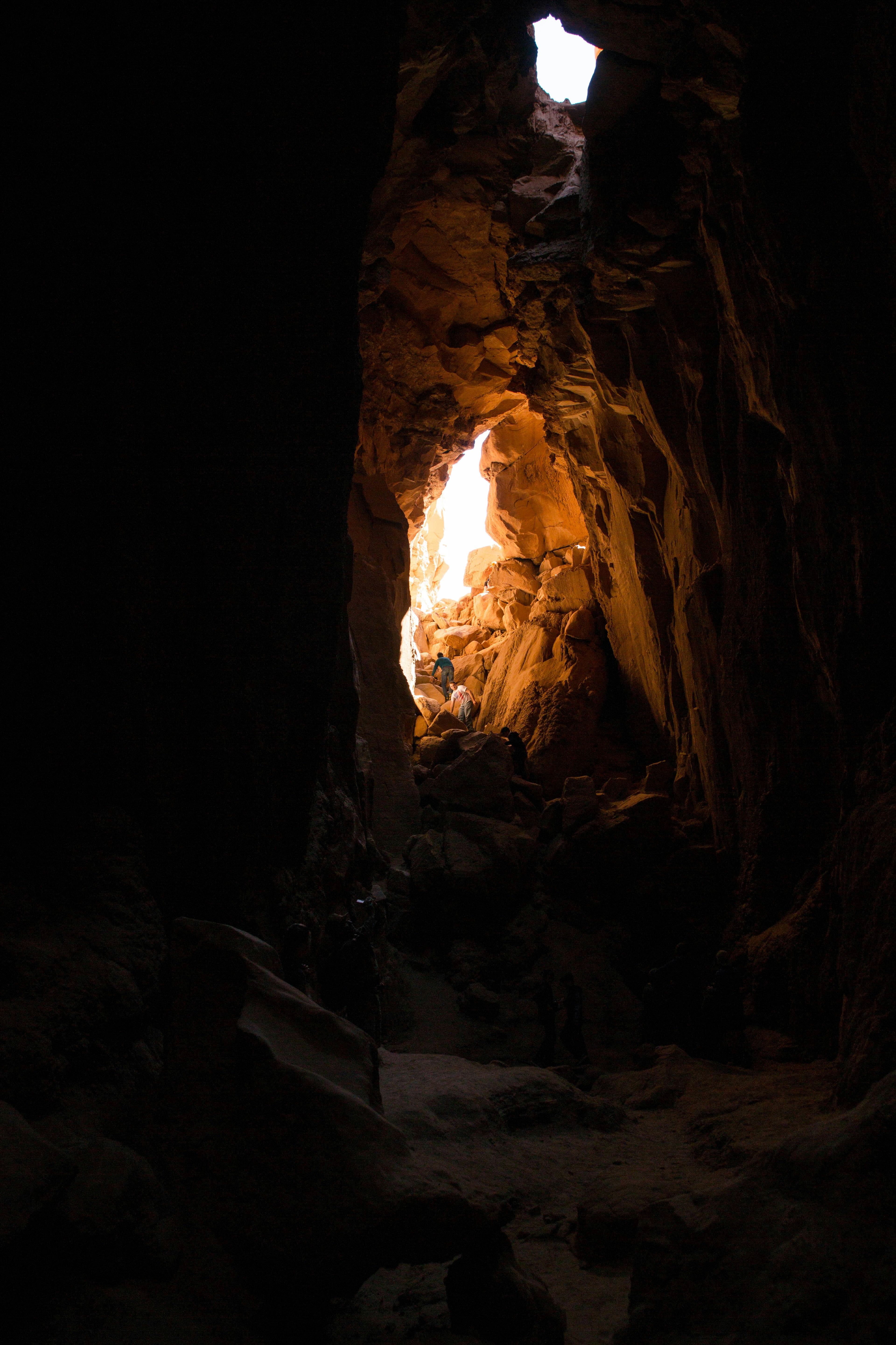 person walking inside the cave during daytime