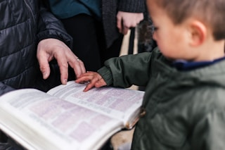 boy touching page of book
