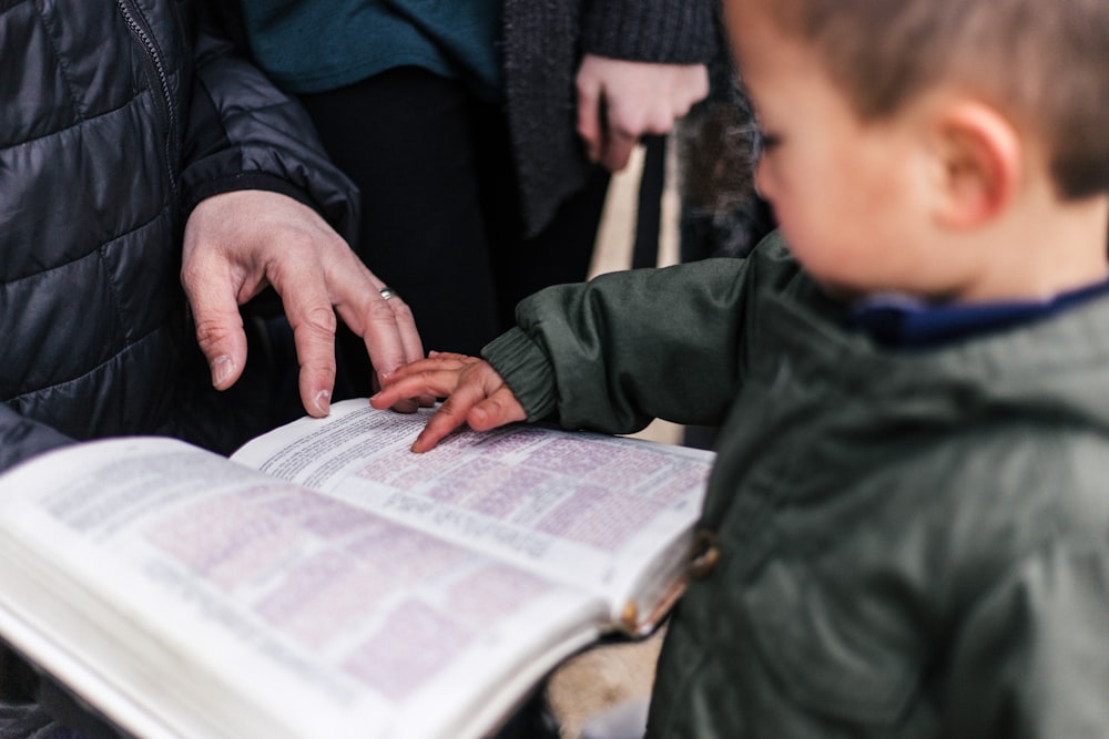 boy touching page of book