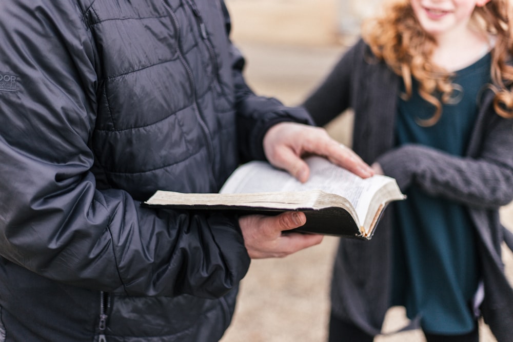 person holding black book