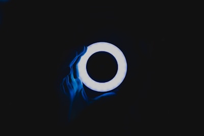 Close-up of a Lumina Ring glowing softly on a finger at night.