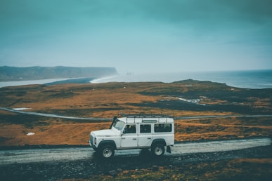 white Jeep SUV on gray rocky road during daytime