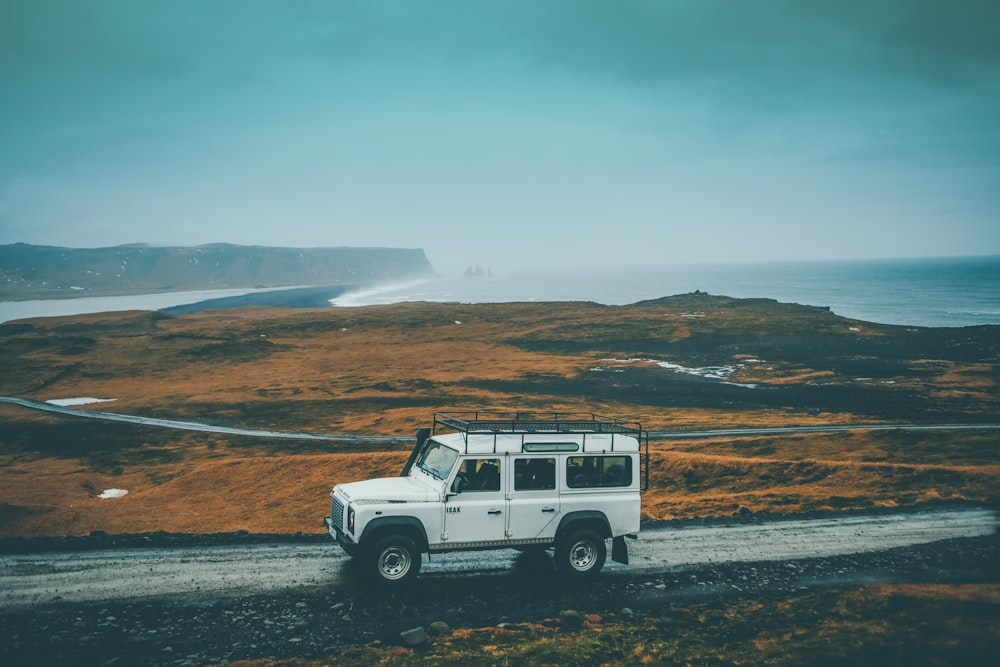 낮에는 회색 바위 도로에 흰색 지프 SUV