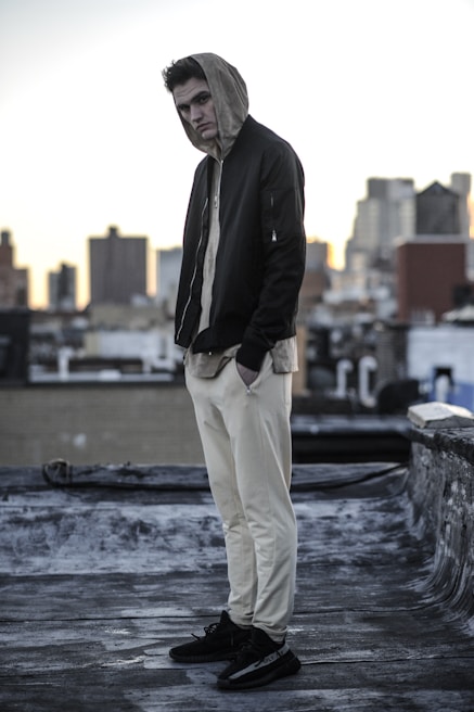 Model wearing a sleek anxiety clothing jacket on an urban rooftop at dusk