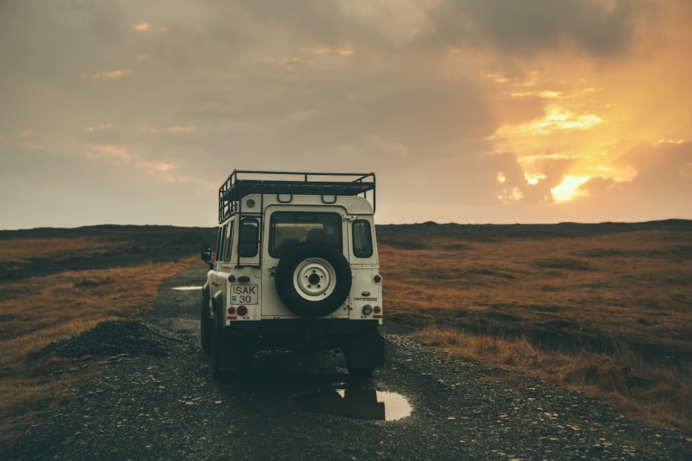 Wrangler blanco en la carretera durante la puesta de sol