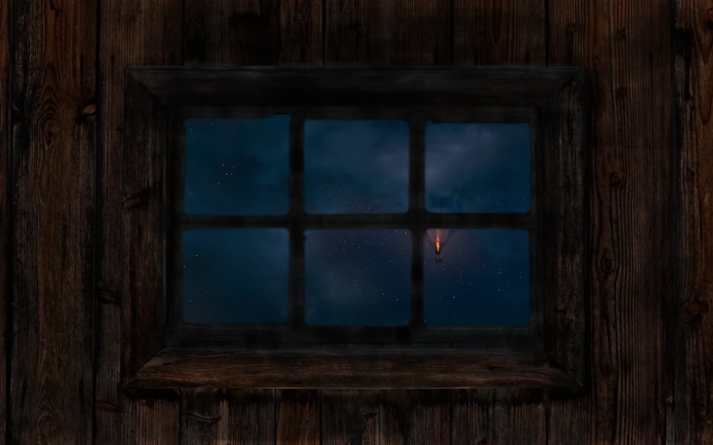 rectangular 6-pane window on brown wooden wall at nighttime