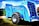 A large, blue agricultural machine with a prominent tire and multiple mechanical components is displayed outdoors on a grassy area. The machine is labeled with various markings, including 'Euromilk Buffalo RX900.' The backdrop includes other machinery and a partly cloudy sky.
