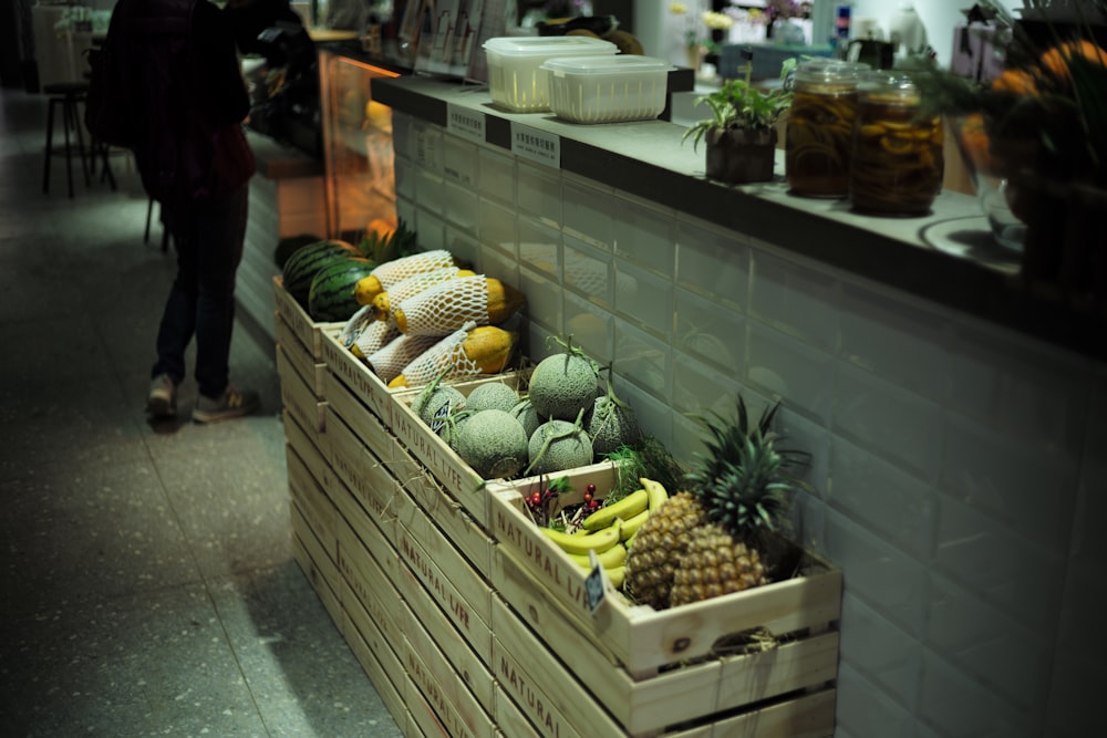 fruits in crates beside wall