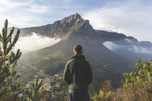 man standing in front of mountain