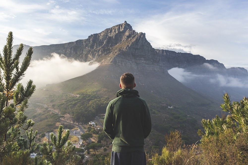 man standing in front of mountain