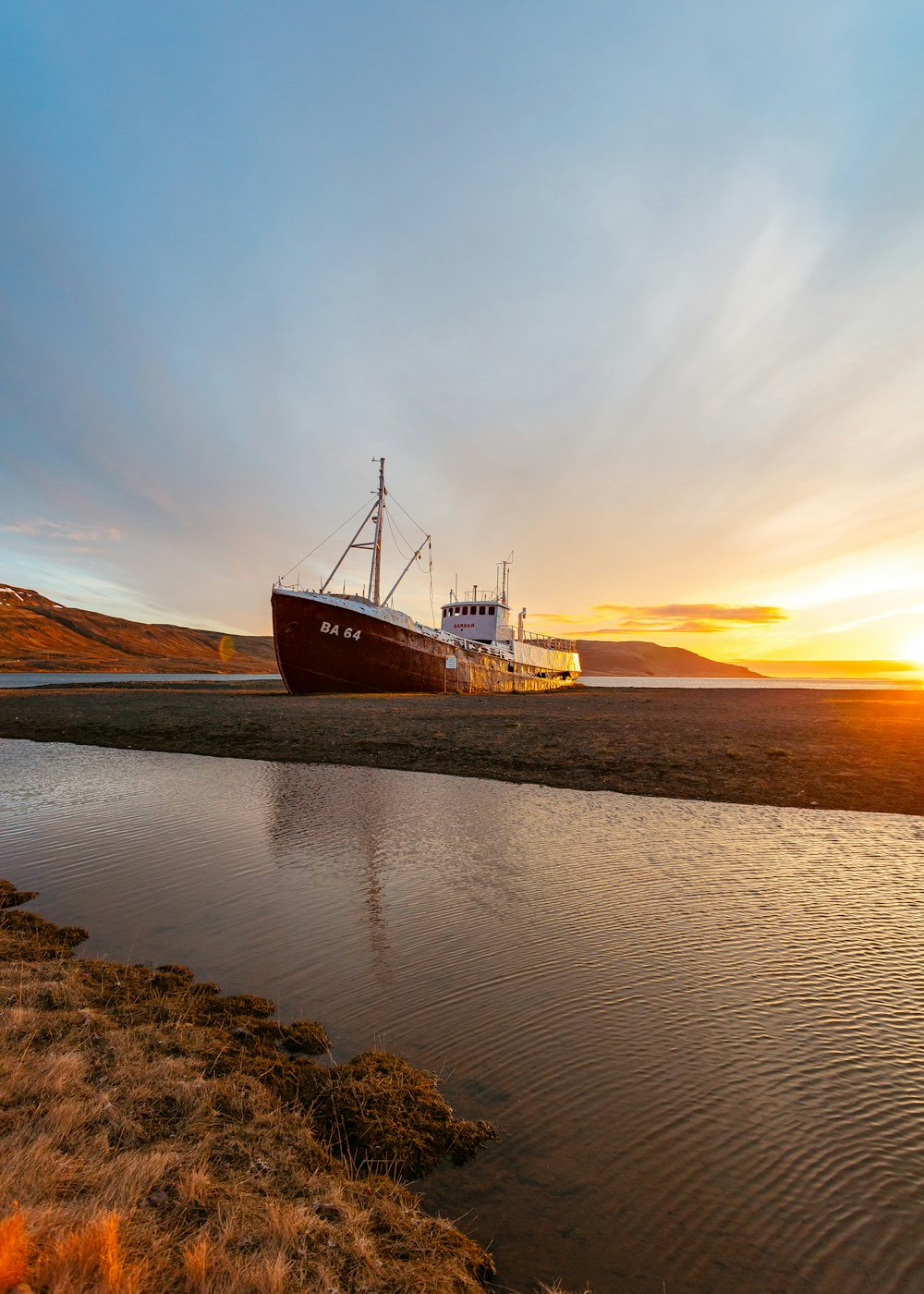 white and brown ship on seashore under sunrise