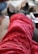 A person is lying down with their feet up, wearing fuzzy red patterned pants and thick socks. The focus is on the legs and feet, giving a cozy and relaxed atmosphere.