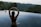 woman in infinity pool making heart hand gesture facing green leafed trees