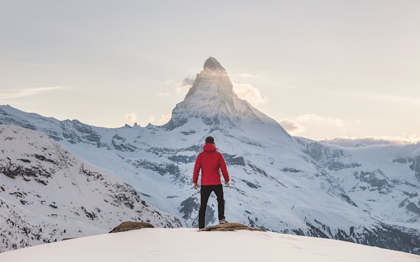 Mann steht auf Berggipfel 