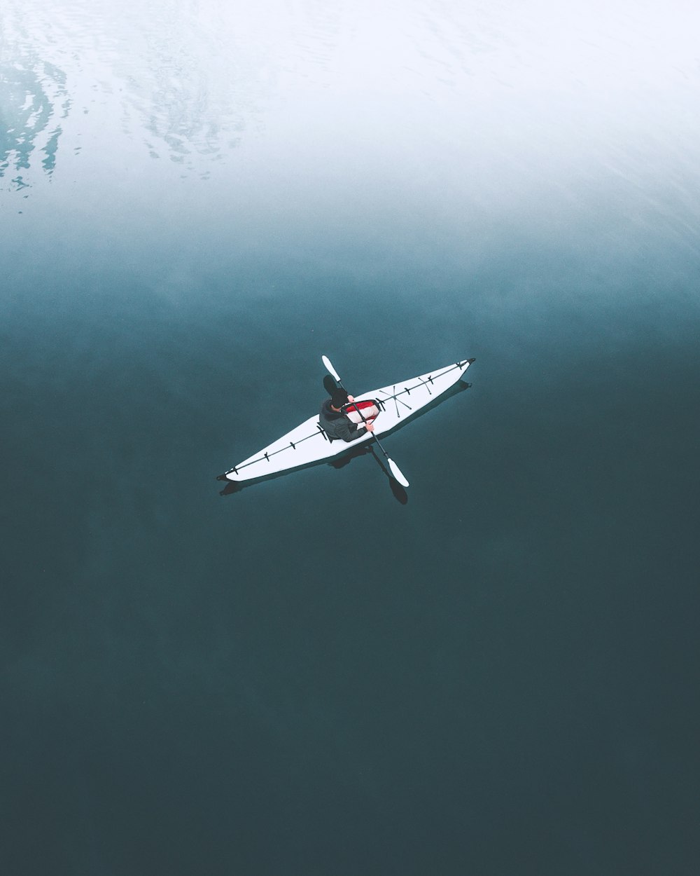 man in kayak on body of water during daytime