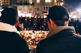 A candlelight vigil held at dusk with community members holding photos.