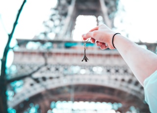 person holding Eiffel Tower keychain